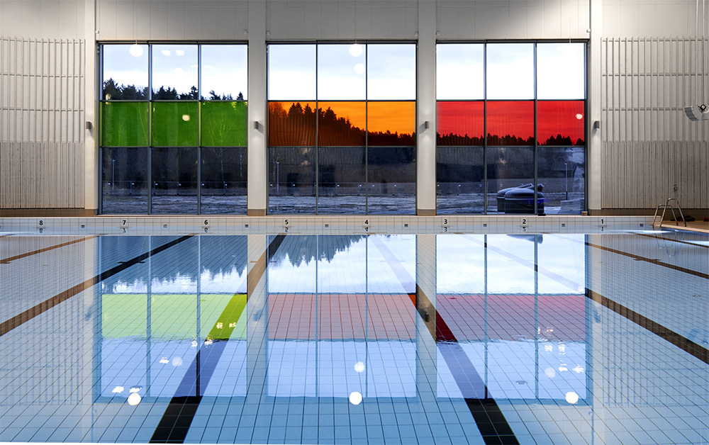 Bild som visa en simbassäng och färgade fönster.